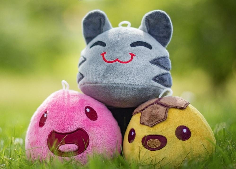 Three soft plush collectibles sitting in the grass